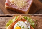 Délicieux croque madame avec œuf au plat sur le dessus, servi dans une assiette.