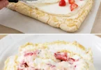 Meringue roulée aux fraises et aux amandes prête à être dégustée.